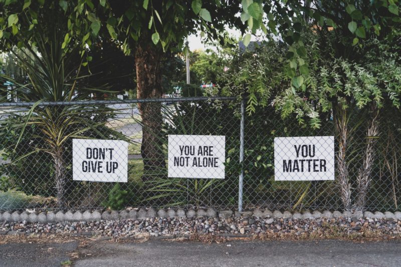 Inspirational signs hanging on a fence